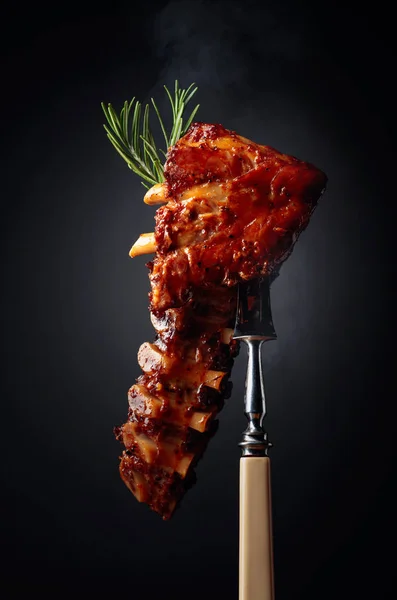 Grilled pork ribs with rosemary on a fork. — Stock Photo, Image