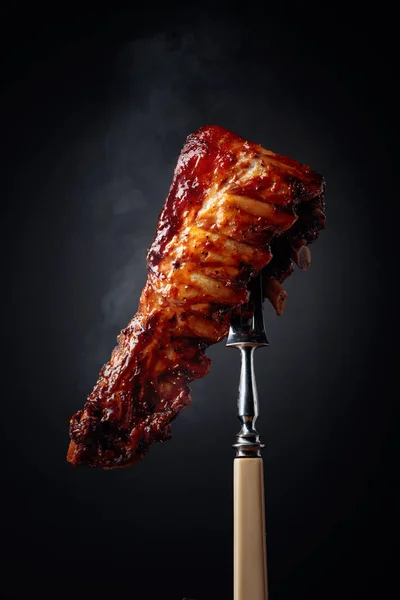 Grilled pork ribs on a fork. — Stock Photo, Image