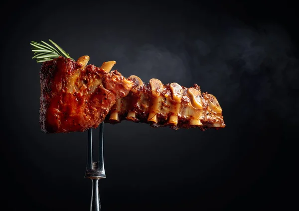 Grilled pork ribs with rosemary on a fork. — Stock Photo, Image