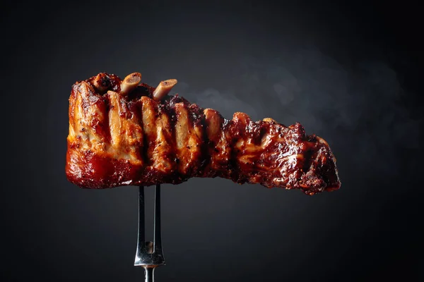 Grilled pork ribs on a fork. — Stock Photo, Image