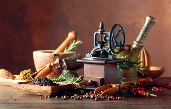 Vintage pepper mill with kitchen utensils and spices. — Stock Photo, Image