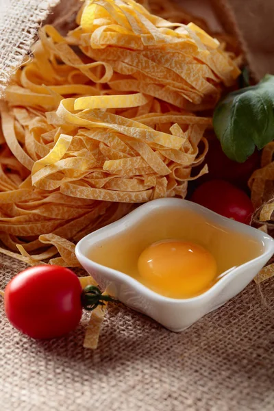 Homemade raw noodles with egg, tomato and basil. — Stock Photo, Image