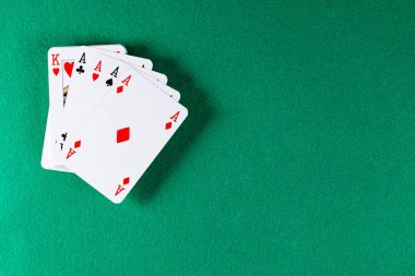 Playing cards on green cloth in a casino. 