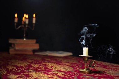 Extinguished candle on a dark background.