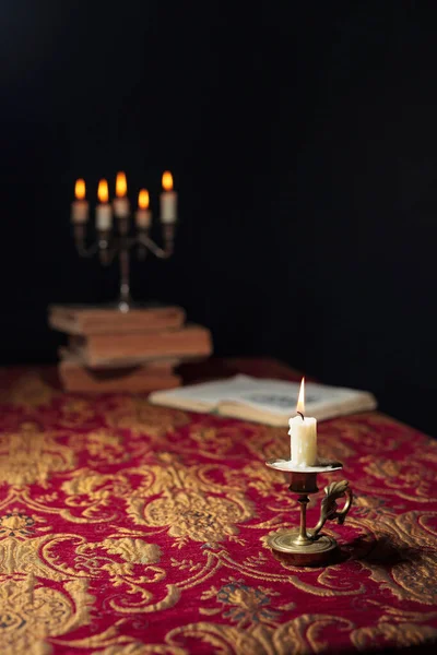 Queimando vela em um fundo escuro com a silhueta do c — Fotografia de Stock