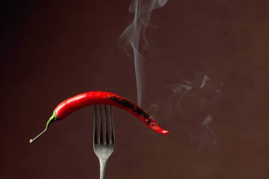 Kırmızı biber çatalda sigara içiyor. Baharat konsepti. 