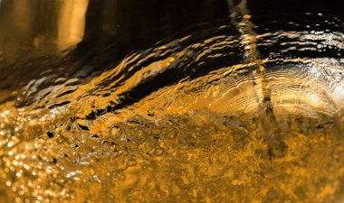 Karanlık bir arka plan üzerinde alkollü içki, soyut sıçrama.