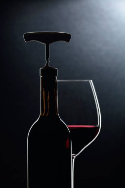 Tirbuşonlu şişe ve bir bardak kırmızı şarap..