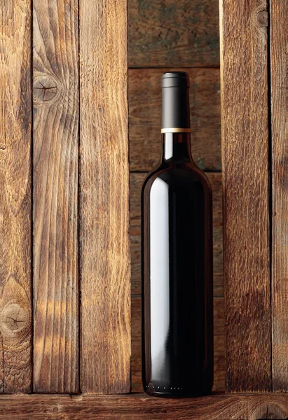 Botella de vino tinto sobre un viejo fondo de madera . —  Fotos de Stock