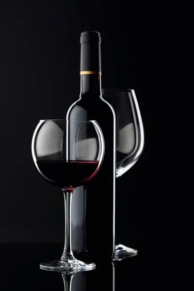 Bottle and glasses of red wine on a black background. — 스톡 사진