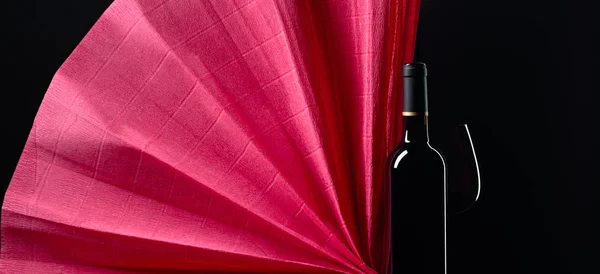 Gesloten fles en glas rode wijn op een zwarte achtergrond. Begrepen. — Stockfoto