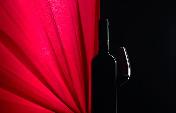Closed bottle and glass of red wine on a black background. Copy — 스톡 사진