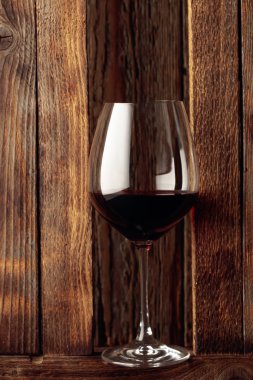 Eski ahşap arka planda bir kadeh kırmızı şarap.. 