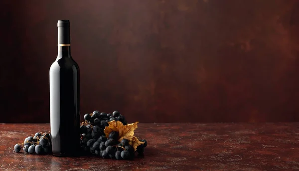 Красное вино и виноград на коричневом фоне . — стоковое фото