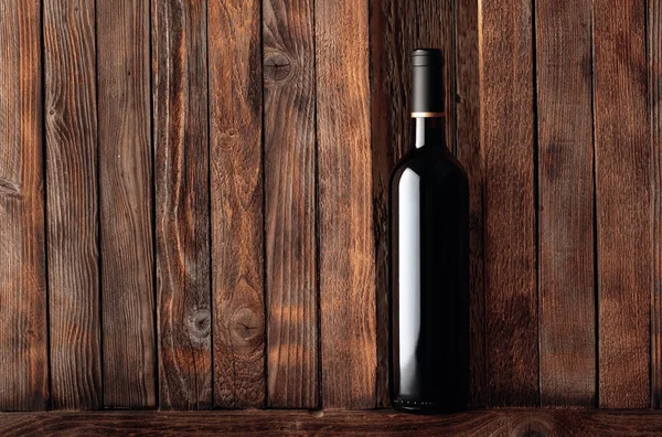 Botella de vino tinto sobre un viejo fondo de madera . —  Fotos de Stock