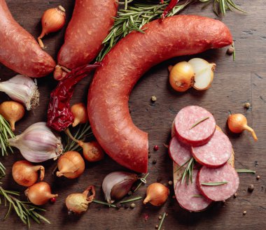 Eski ahşap bir masada salamlı sandviç..