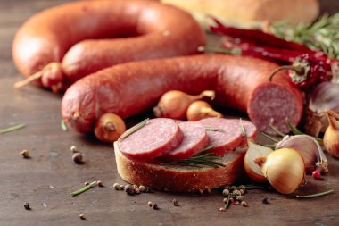 Eski ahşap bir masada salamlı sandviç..