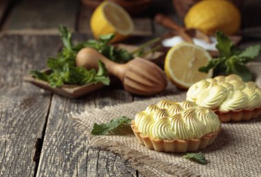 Tahta bir masada limon kremalı ve naneli tart.. 