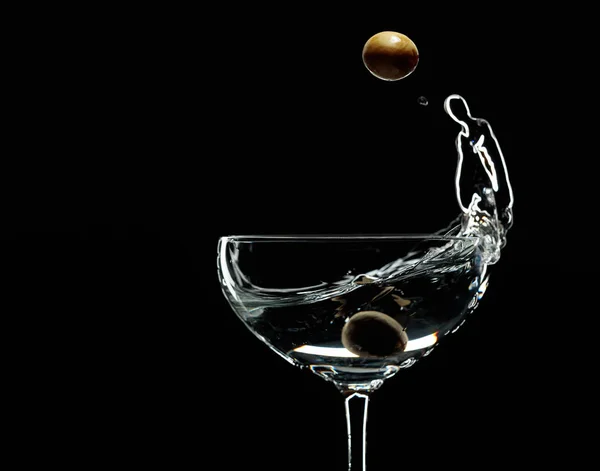 Silueta de martini con aceitunas verdes sobre fondo negro . — Foto de Stock