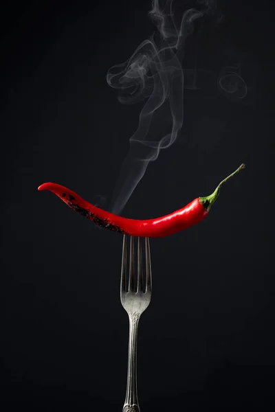 Pimienta roja picante fumando en un tenedor. Concepto de especias . — Foto de Stock