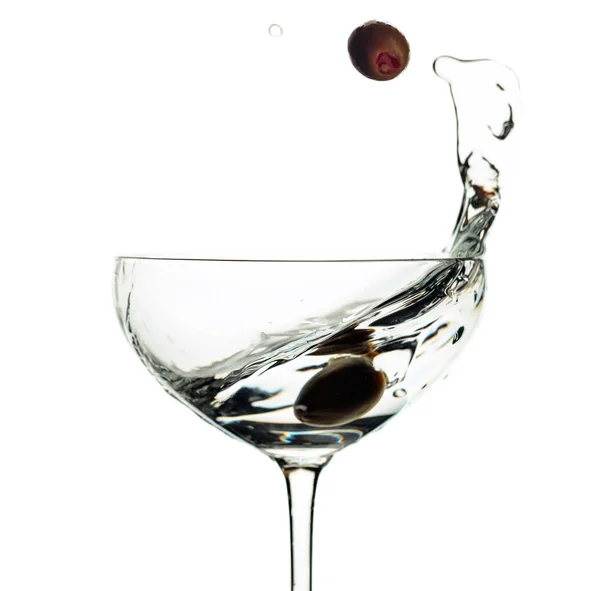 Martini et olives vertes en verre avec éclaboussures isolées sur du blanc — Photo