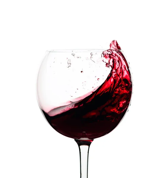 Splash του κόκκινου κρασιού σε ένα ποτήρι που απομονώνονται σε λευκό. — Φωτογραφία Αρχείου