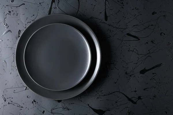 Άδειο μαύρο πιάτο σε μαύρο φόντο. Άνω όψη. — Φωτογραφία Αρχείου
