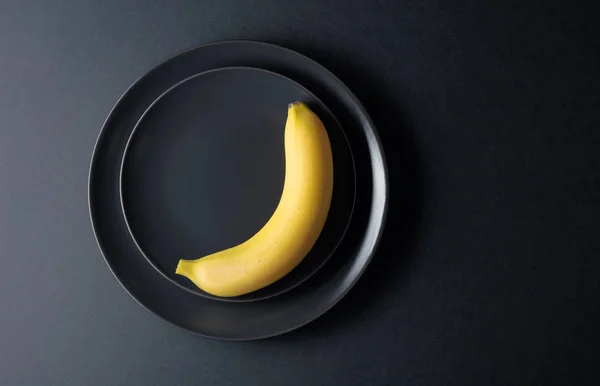 黒皿にジューシーなバナナを熟す. — ストック写真