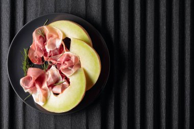 Biberiyeli jambon ve siyah tabakta kavun.. 