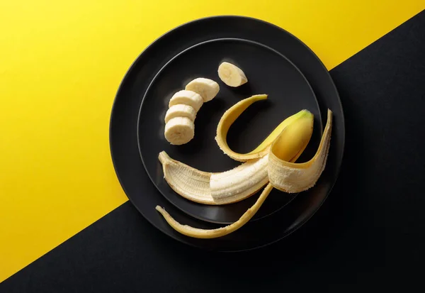 Mogen saftig banan på en svart tallrik. — Stockfoto