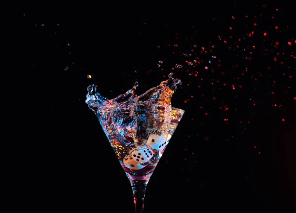 Dice fall in a glass of martini. Colourful cocktail in glass wit — Stock Photo, Image