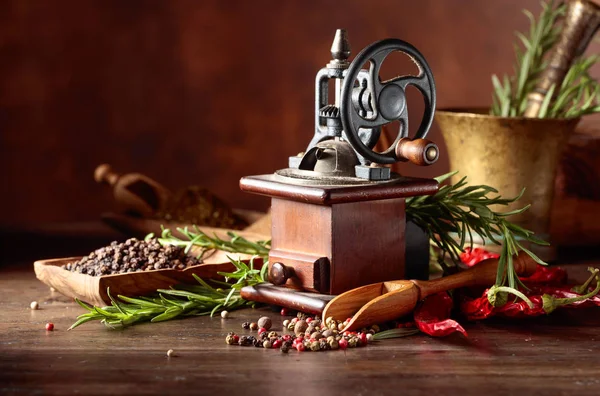 Molino de pimienta vintage con utensilios de cocina, especias y romero o — Foto de Stock