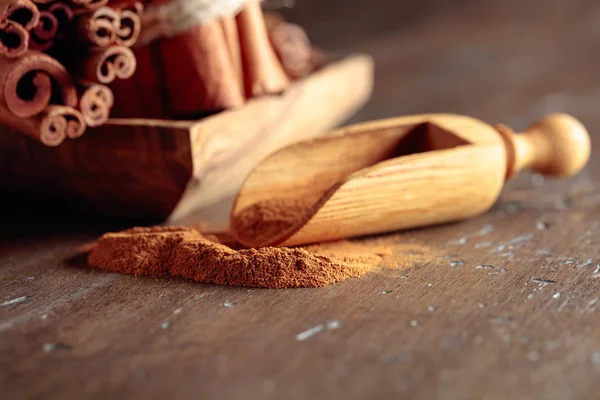 Cinnamon sticks and powder on a wooden table. — Stock Photo, Image