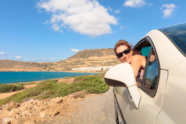 Glückliche reife Frau mit Sonnenbrille im Auto bei strahlendem Sonnenschein — Stockfoto