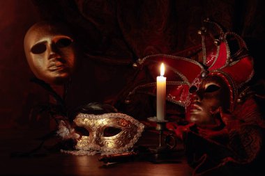 Karnaval maskeleri ve yanan mumlu küçük pirinç şamdanlar.. 