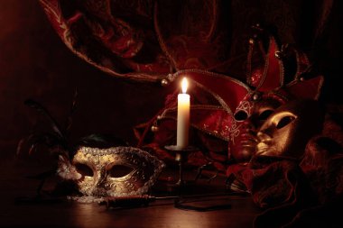 Karnaval maskeleri ve yanan mumlu küçük pirinç şamdanlar.. 