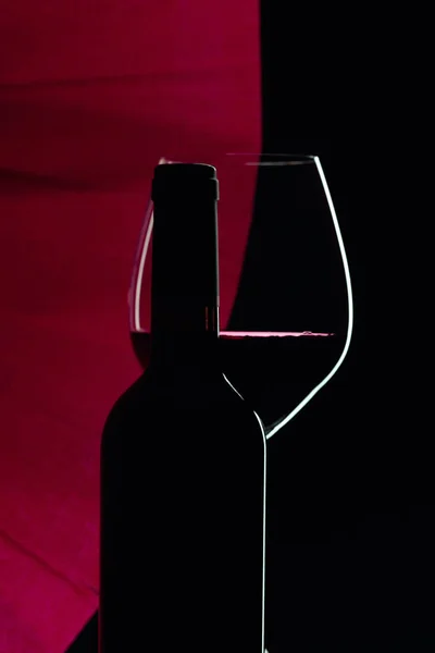 Uzavřená láhev a sklenice červeného vína na černém pozadí. Kopie — Stock fotografie