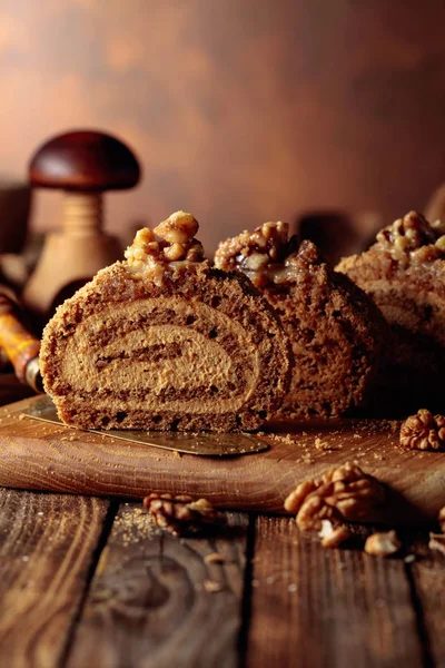 Walnut cake, nuts and wooden kitchen utensils on a wooden table. — Stock Photo, Image