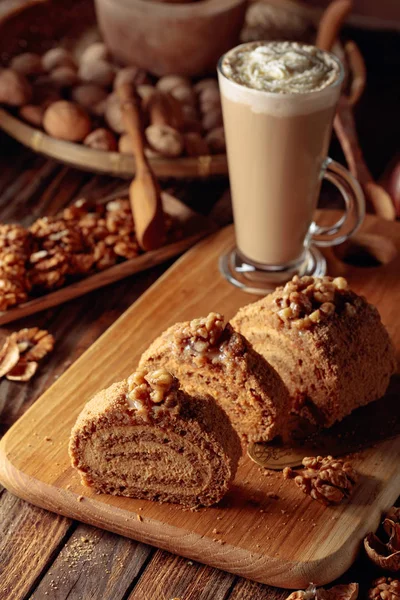 Walnut cake and coffee latte with cream on a wooden table. — Stock Photo, Image