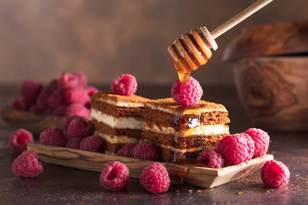 Rétegelt mézes torta tejszínnel és vörös málnával. — Stock Fotó