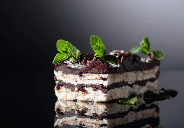 Delicioso pastel de chocolate con menta sobre un fondo reflectante . — Foto de Stock