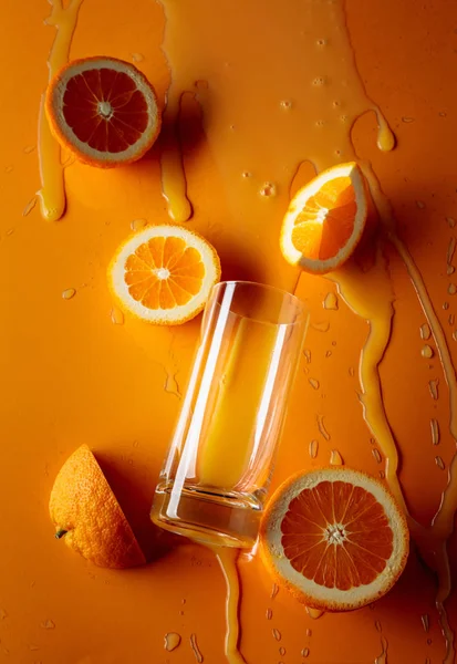 오렌지 주스와 오렌지 배경에 과일을 곁들인 오렌지 주스. — 스톡 사진