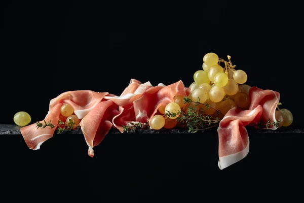 Akdeniz atıştırmalıkları. Prosciutto ve kekikli üzümler. — Stok fotoğraf