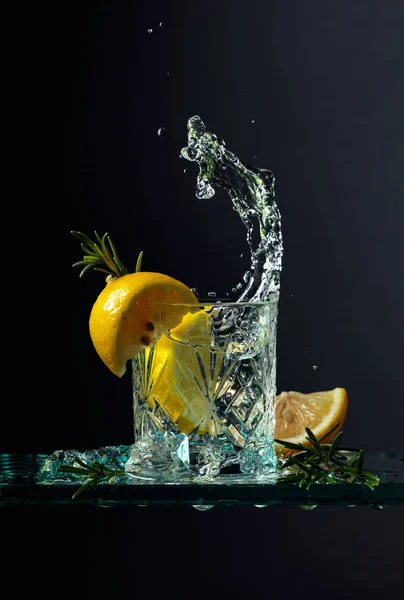 Cocktail gin-tonic cu lămâie și rozmarin pe o masă de sticlă . — Fotografie, imagine de stoc