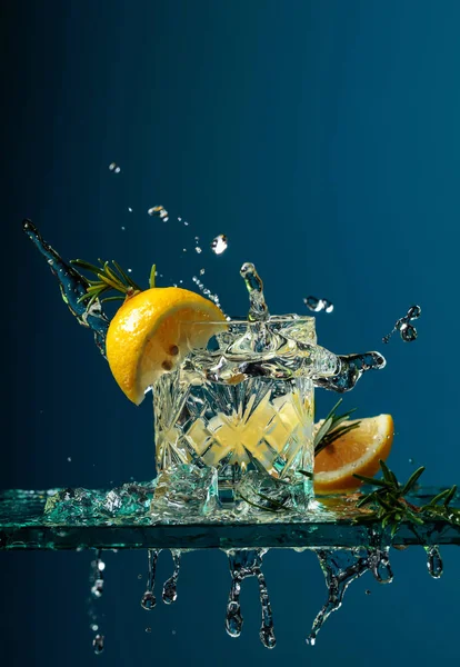 Gin koktajlowy z cytryną i rozmarynem na szklanym stole. — Zdjęcie stockowe