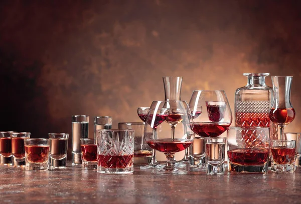 Различные алкогольные напитки в стаканах на коричневом фоне . — стоковое фото