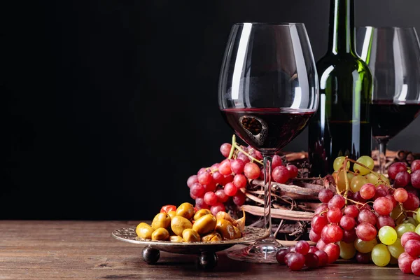 Red wine with spicy green olives and grapes. — Stok fotoğraf