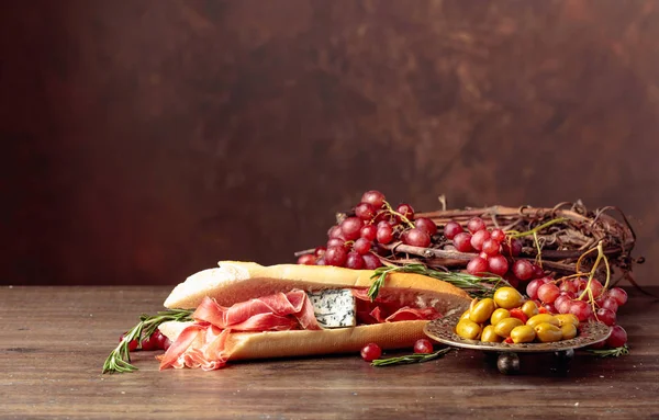 Sandwich with prosciutto, blue cheese and rosemary on a dark bac — Stock Photo, Image