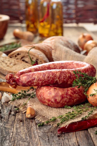 Worst met brood en specerijen op een oude houten tafel. — Stockfoto