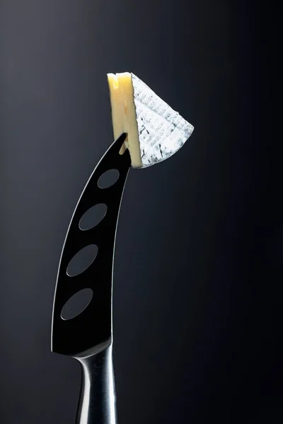 Soft cheese on a knife. — Stock Photo, Image